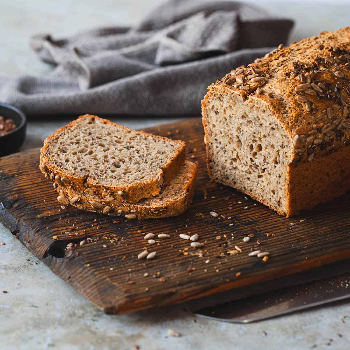 Dinkelbrot frisch selber gebacken und angeschnitten auf einem Holzbrett