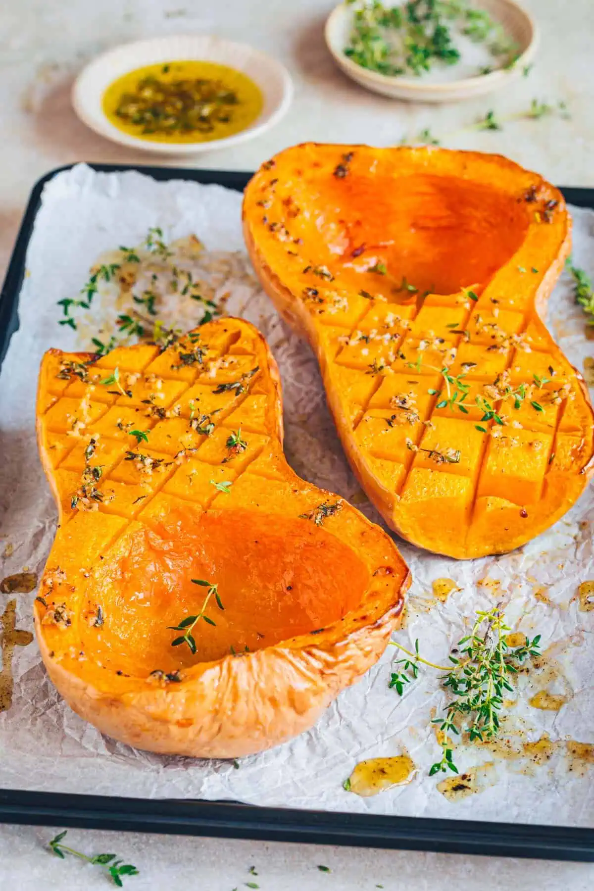 1-5 Butternut-Kürbis auf einem Backblech mit Marinade und Thymian.