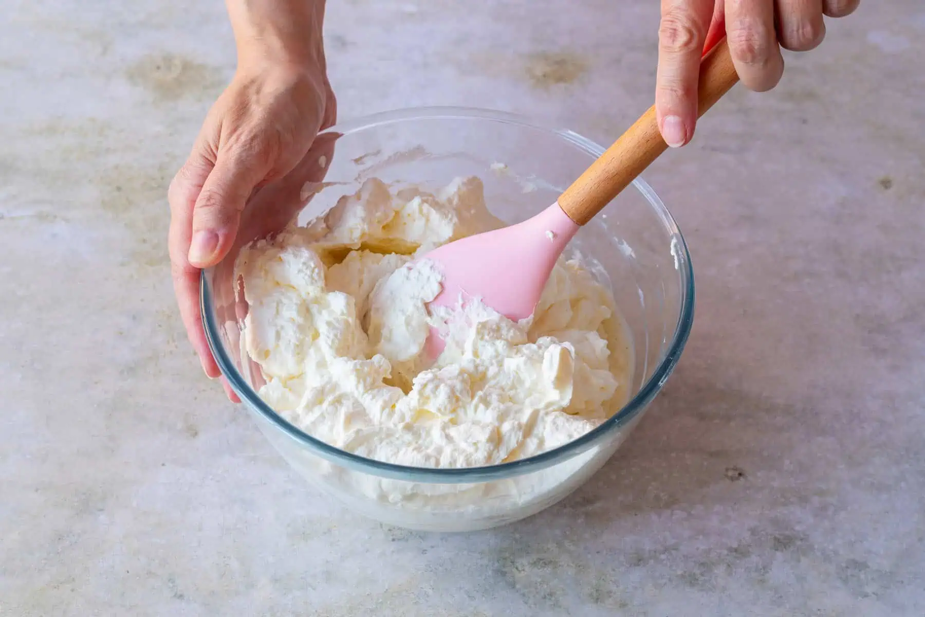 Sahne wird unter Mascarpone-Creme gehoben.